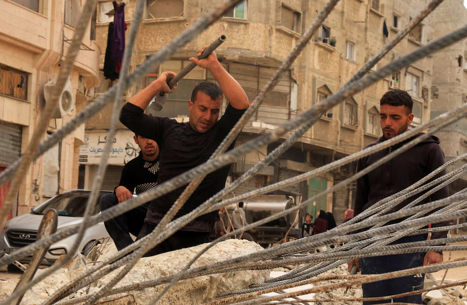 الغزيون المتعبون ينتزعون قضبان الحديد من بين الركام لبناء الخيام وكسب رزقهم 10 الغزيون المتعبون ينتزعون قضبان الحديد من بين الركام لبناء الخيام وكسب رزقهم