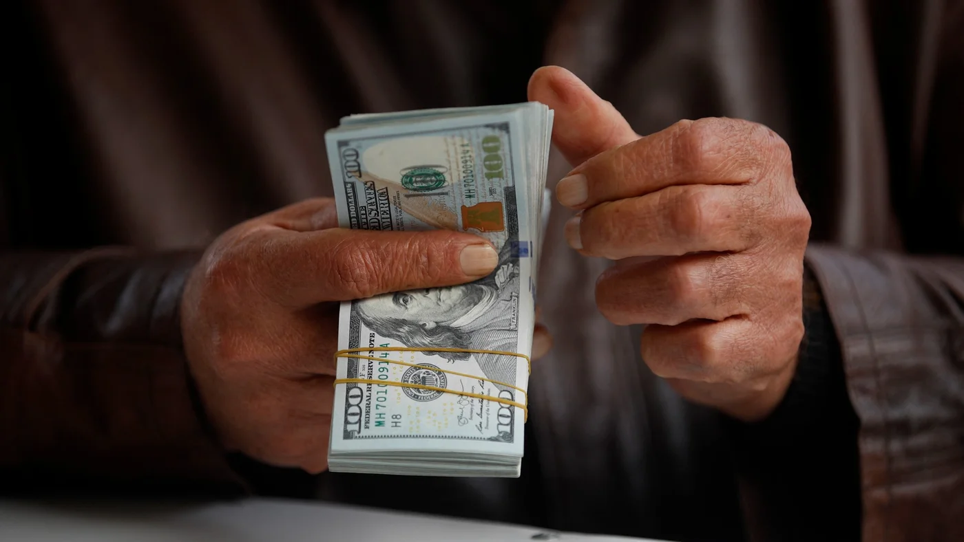 iraq man counts us dollars basra 2022 27 dec afp.jpg